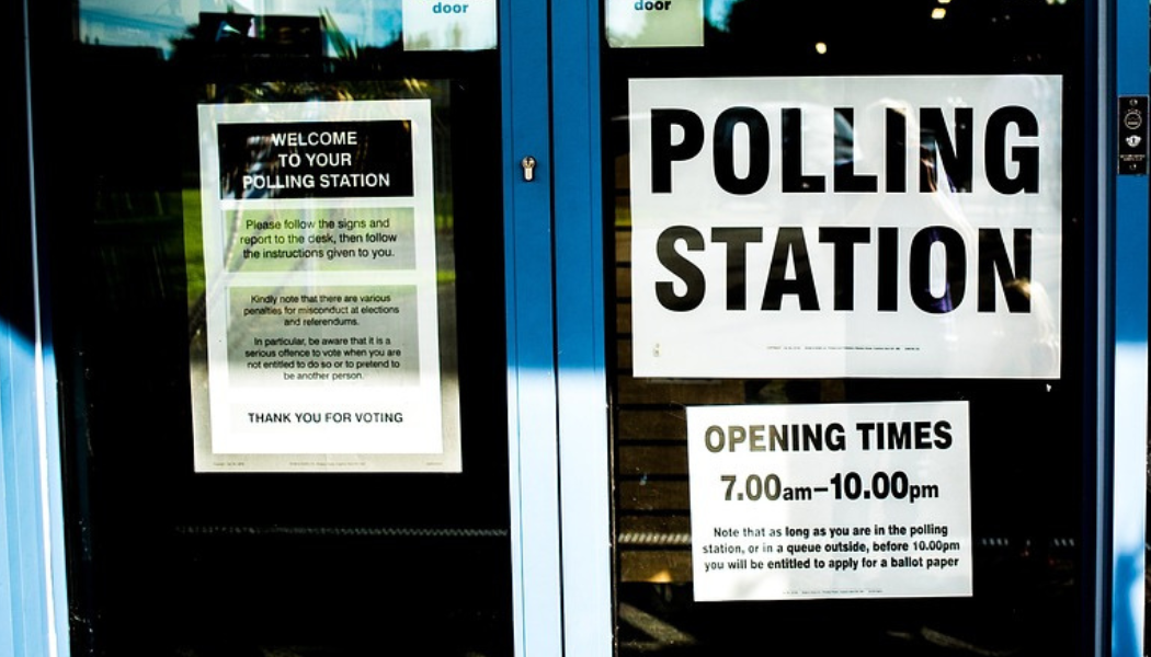 Glass doors with polling station sign. Pexels.